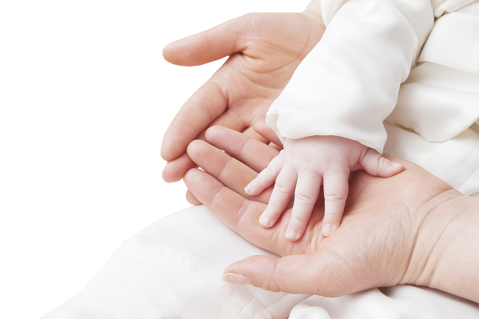 A close-up of a baby's hand resting gently in an adult's hand