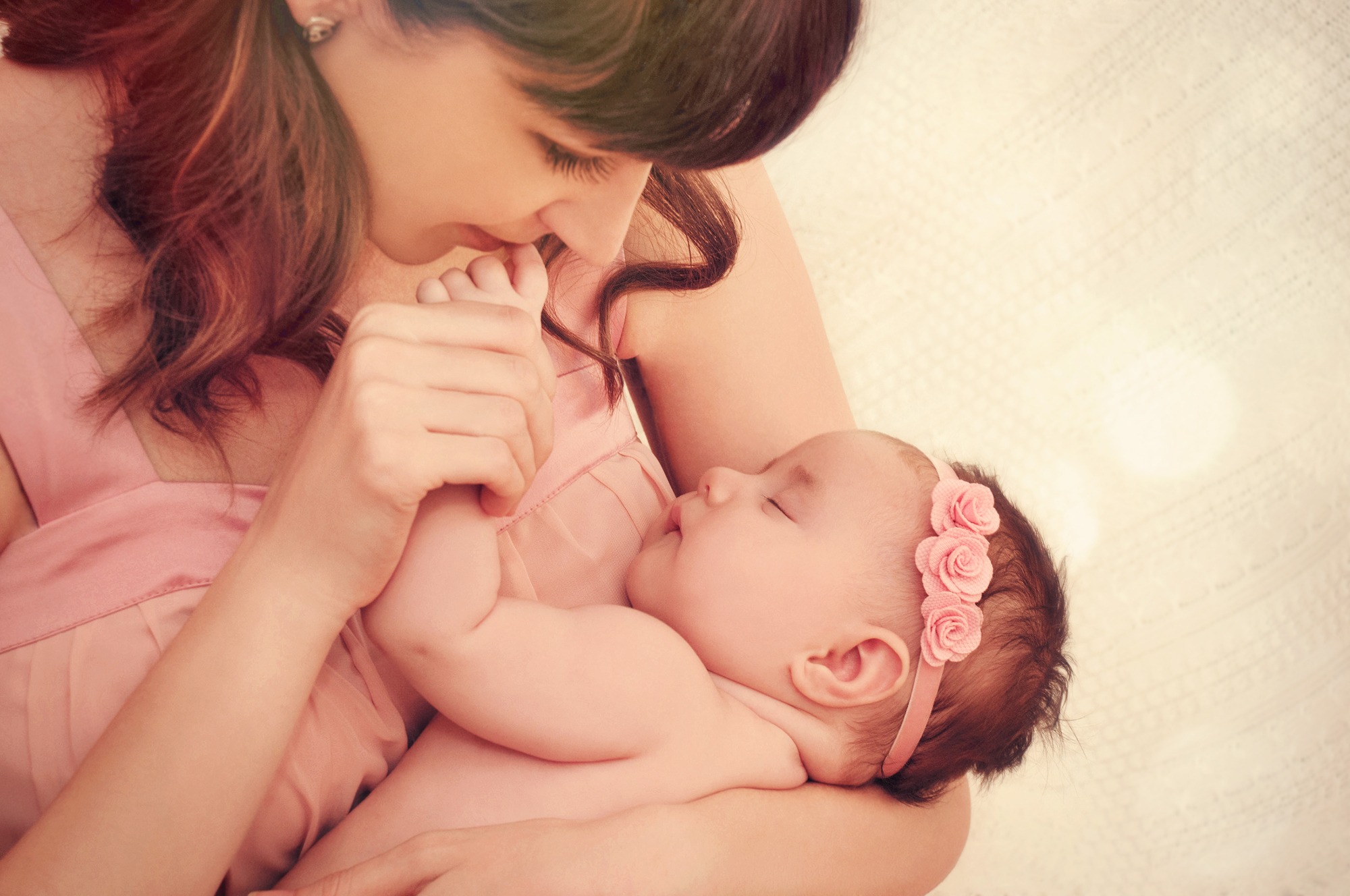 Caring Mother Kissing Little Fingers Of Her Cute Sleeping Baby Girl