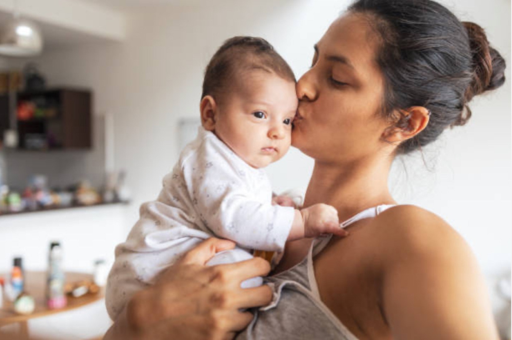 A mother kisses her baby